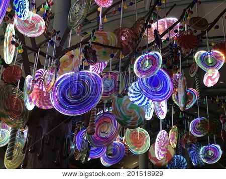Numerous colorful lollipop candies hanging illumintated light