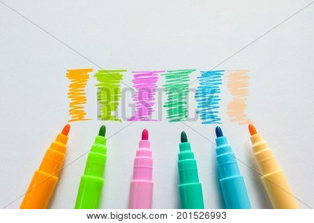 Colorful magic pens writing on paper background.
