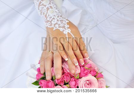 Bride and groom holding hands outdoors and flowers