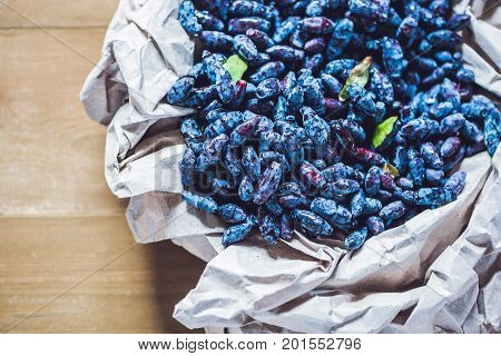 Fresh Honeysuckle Blue Berry Fruits With Leaf On A Wooden Background