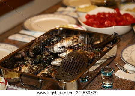 Fish grill / There are fish on the grill and grilled. An raw freshwater fish on the grill. Cooked in traditional style. Cooking of salted fish on a grill stove.