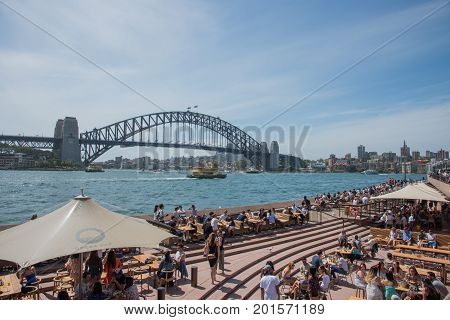 SYDNEY,NSW,AUSTRALIA-NOVEMBER 20,2016: Tourists at the Opera Bar on the Parramatta River waterfront with Sydney Harbour Bridge View in Sydney, Australia