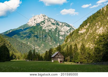 A beutiful landscape in the mountains, clouds above peaks and forest in foreground, European Alps, Robanov kot, Slovenia