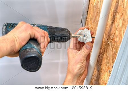 Installation of the wall home piping the installer fixes the bracket on the wall using a screwdriver.