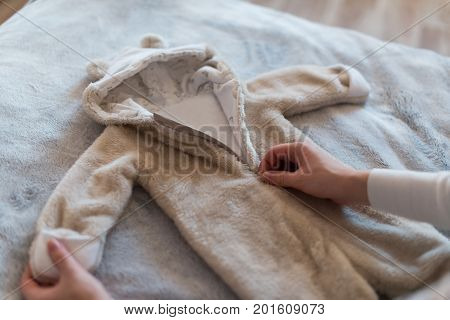 Pregnant woman dreaming and holding baby's clothes.