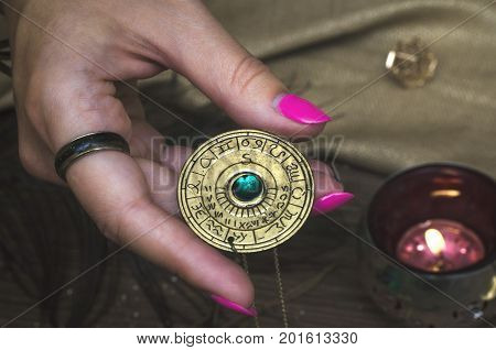 Amulet with zodiac signs in fortune teller hands. Divination. Witchcraft. Horoscope.