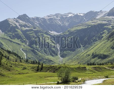 Alpine massif, beautiful Alpine canyon in Austria. Alpine Gastein Valley in summer. Mountains and pastures. Fresh air and healthy virgin nature. Excursional destination for hiking, vacation.