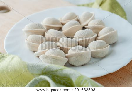 Frozen Dumplings On The White Plate With Green