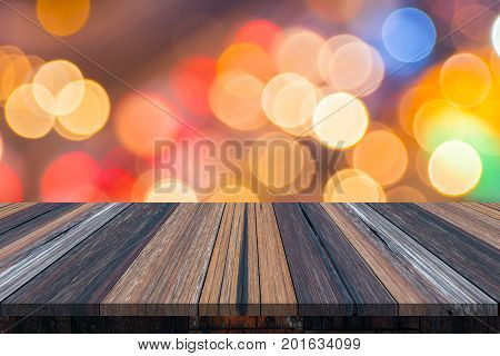 Empty old painted color wooden table or plank with bokeh of light from road or street with city tower on background for product display.