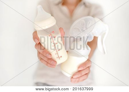 Breast Pump And Bottle With Milk In Woman's Hand