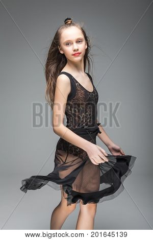 smiling cute young girl dancing. model dressed in a black and leopard pattern dance dress. red lips. kontemp, hip-hop