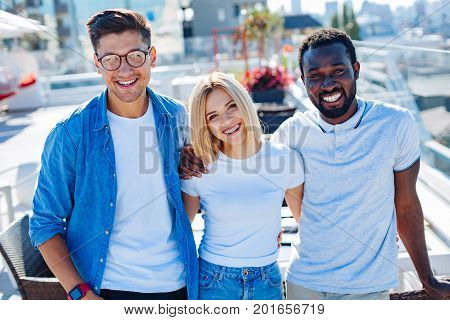 No time for warries. Friendly team of university people in casual beaming into the camera while spending time outdoors and enjoying their weekend.
