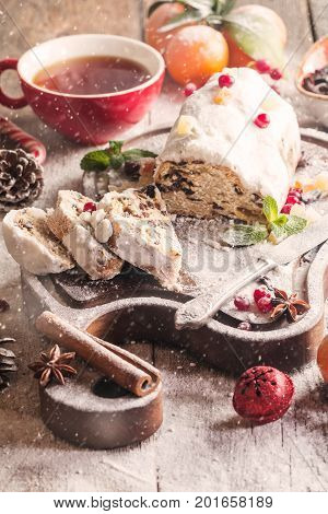 Christmas stollen, traditional German, European festive dessert cut into pieces on wooden background.
