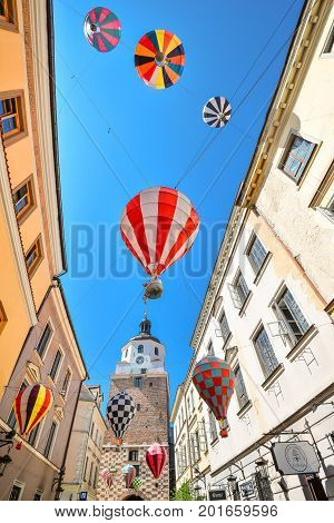 Lublin, Poland - August 10, 2017: Beautiful street and old bright buildings in the old town of Lublin, Poland. Brama street, view on Cracow gate, Lublin. Mountebanks Carnaval in Lublin old town.