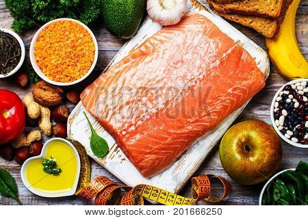 Fresh raw salmon fillet and ingredients on kitchen table