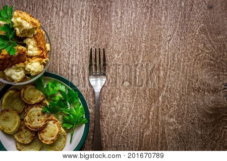 Cauliflower and zucchini baked in batter on a wooden background. Top view. Copy space. Still life. Flat lay