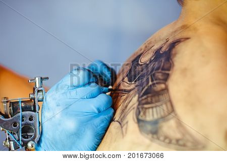 Russia Novokuzneck 5.07.2017: The tattoo artist makes a tattoo on the client's neck in the tattoo salon. The master does a tattoo in the studio. Close-up. Hard. Pain.