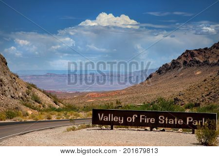 Valley of fire sign at the entrance of the national park with mountains in background