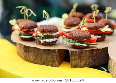 Healthy vegan raw burger. Healthy fast food on a cutting wooden board.