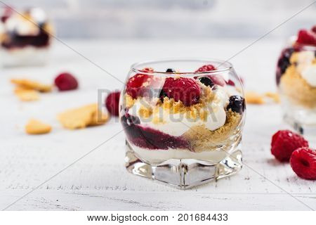 Homemade dessert in glass jars. Cheesecake, trifle, mouse on white wooden background. Copy space