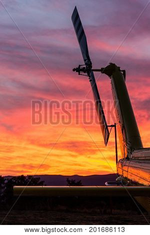 A tail rotor view of a helicopter in a stunning sunset