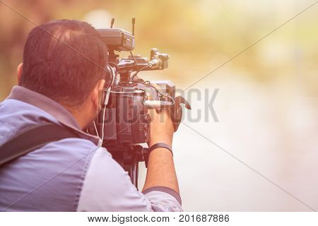 Cameraman Using Professional Digital Video Camera. Outdoor Setup And Working