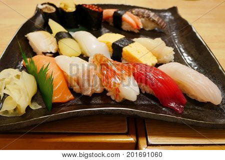 Close up of sashimi sushi set on black plate in Otaru japanese restaurant delicious gourmet menu.