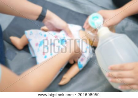 Blurry Background of People are trained to rescue a baby by a child CPR Doll and Ambu Bag.