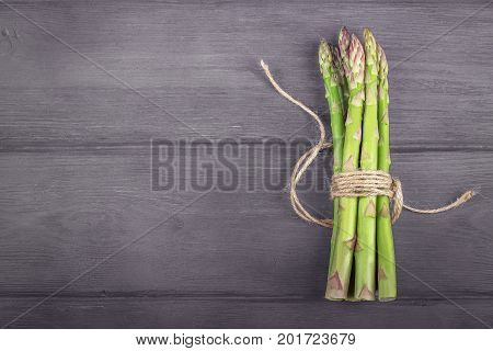 Bunch of fresh asparagus on wooden rustic background. Copy space