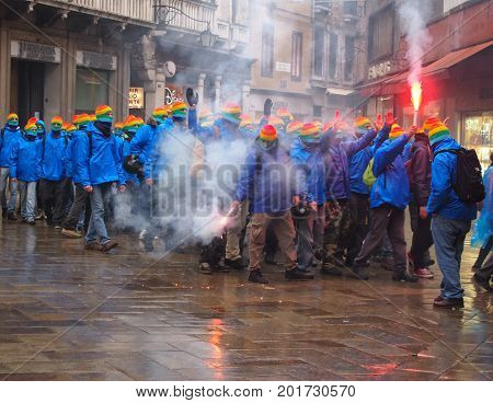 Venice March 03 2015: anti capitalist demonstrators on the streets in venice with masks and flares with smoke