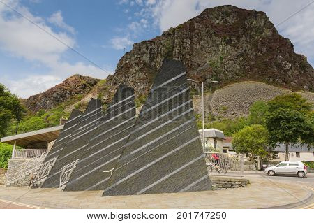 Blaenau Ffestiniog Wales UK - August 22 2017: Mountains towering above the Welsh town of Blaenau Ffestiniog with slate obelisks engraved with Welsh poetry to commemorate the town's mining past