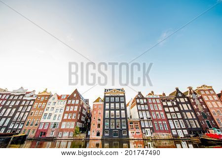 Morning view on the beautiful buildings on the Damrak avenue in Amsterdam. General plan with copy space