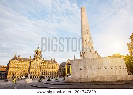 Morning view on the Dam square with Royal palace and monument in Amsterdam city during the sunny weather