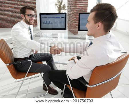 handshake colleagues sitting at your Desk