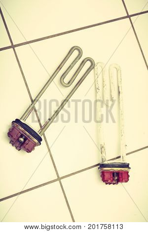 Mechanical technology industry concept. Comparision of two heaters. New washing machine part and old covered in sediment.