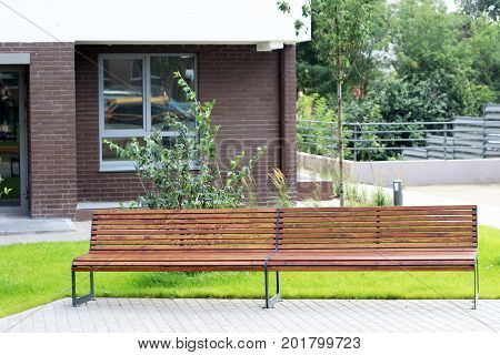 Park Bench In A Spring Garden. New Modern Courtyard.