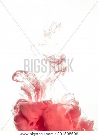 Ink swirl in water isolated on white background. The paint in the water. Soft dissemination a droplets of pink ink in water close-up. Abstract background. Explosion of splashes yellow acrylic ink.