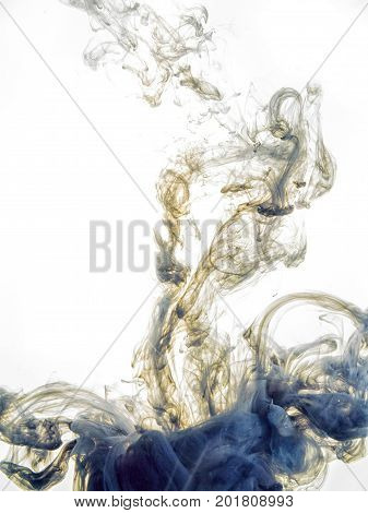 Ink swirl in water isolated on white background. The paint in the water. Soft dissemination a droplets of colored ink in water close-up. Abstract background. Explosion of splashes yellow acrylic ink.