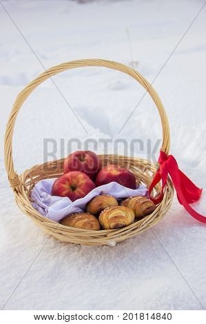 Girl in costume Little Red Riding Hood with dog like a wolf and a basket with apples and pies in the winter in the woods in the snow