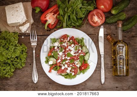 Shopska Salad In A White Plate On A Wooden Background, A Number Of Raw Ingredients Lettuce. View Fro