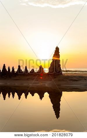 Beach with sandcastles on spectacular Baltic sea sunset background in Latvia. Multicolored summertime outdoors vertical image. Copy space.