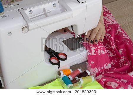 processes of sewing on the sewing machine sew women's hands sewing machine. Female tailor threading leather material on sewing machine. designer making a garment in her workplace