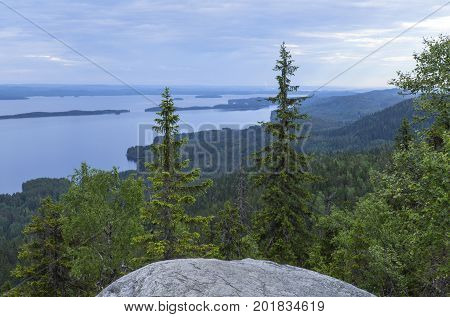 View of lake Pielinen, from Ukko-Koli hill in Karelia, Finland. Rock and trees this side, overcast.