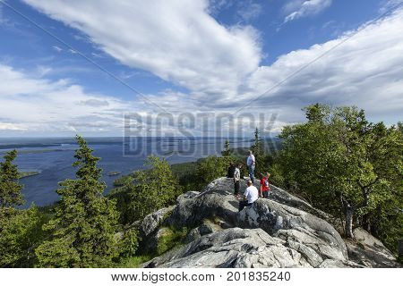 UKKO-KOLI HILL, FINLAND ON JULY 05. View of lake Pielinen from a rock, cliff on July 05, 2017 in Ukko-Koli Hill, Finland. Unidentified people at the outlook. Editorial use.