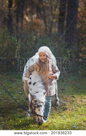 Little Cute Girl Walking With A Pony In The Autumn Forest