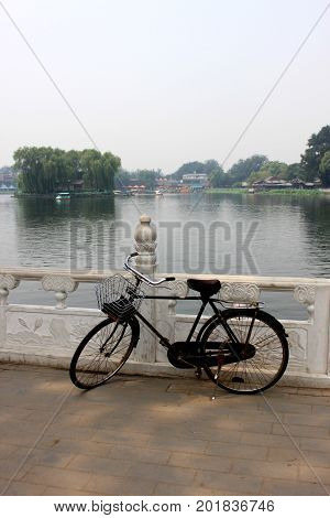 The Old Unused Bike Lay On The Railing Of Houhai Lake Park, Beijing