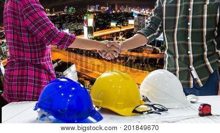 Team of profressional engineers and worker are shaking hands while working safety control city background. Construction Concept.