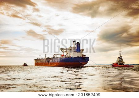 Tug boat towing a tanker ship at sea.