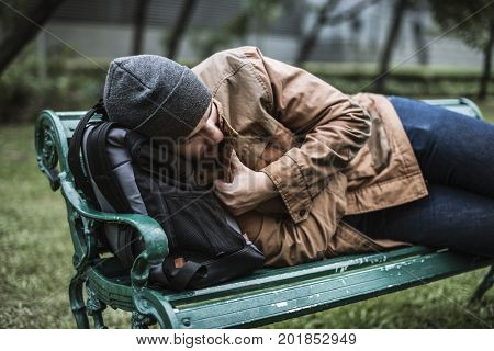 Homeless Adult Man Sleeping on Bench in The Park