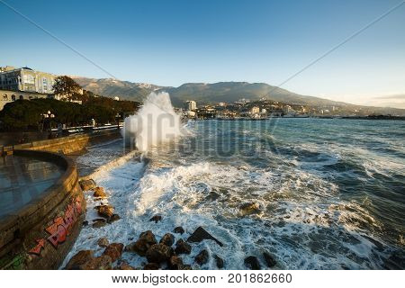 Storm at the sea and embankment street of Yalta city in Crimea in the morning on 24.10.2016. Big waves and tides wash against with lots of splashes.